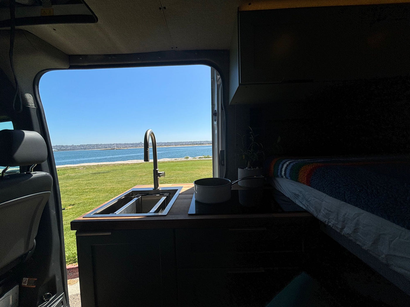 next to teal cabinets on light wood-look flooring.|Cozy RV rental interior with sage green cabinets — photo 11