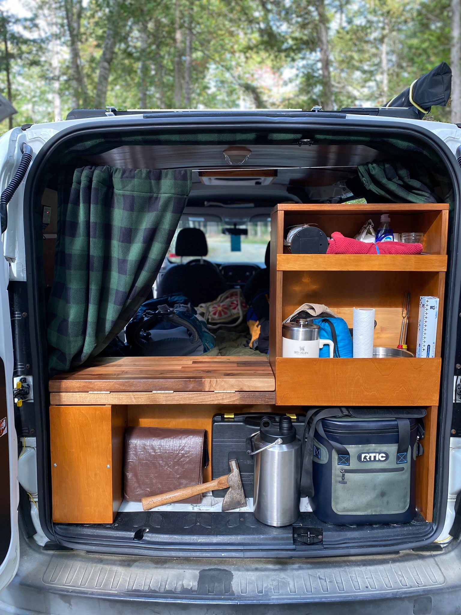 and a peaceful forest view through the large window.|Compact rv rental interior featuring a wood ceiling