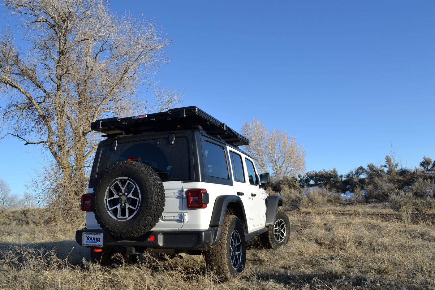 White Jeep Wrangler with a rooftop tent, an ideal RV rental for off-road camping and adventure.