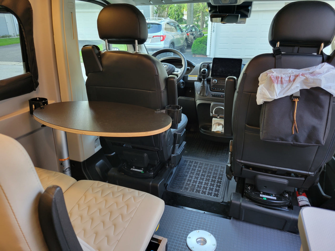 Rv rental interior: swiveling front seats, a removable table, and a compact workspace, great for mobile living.