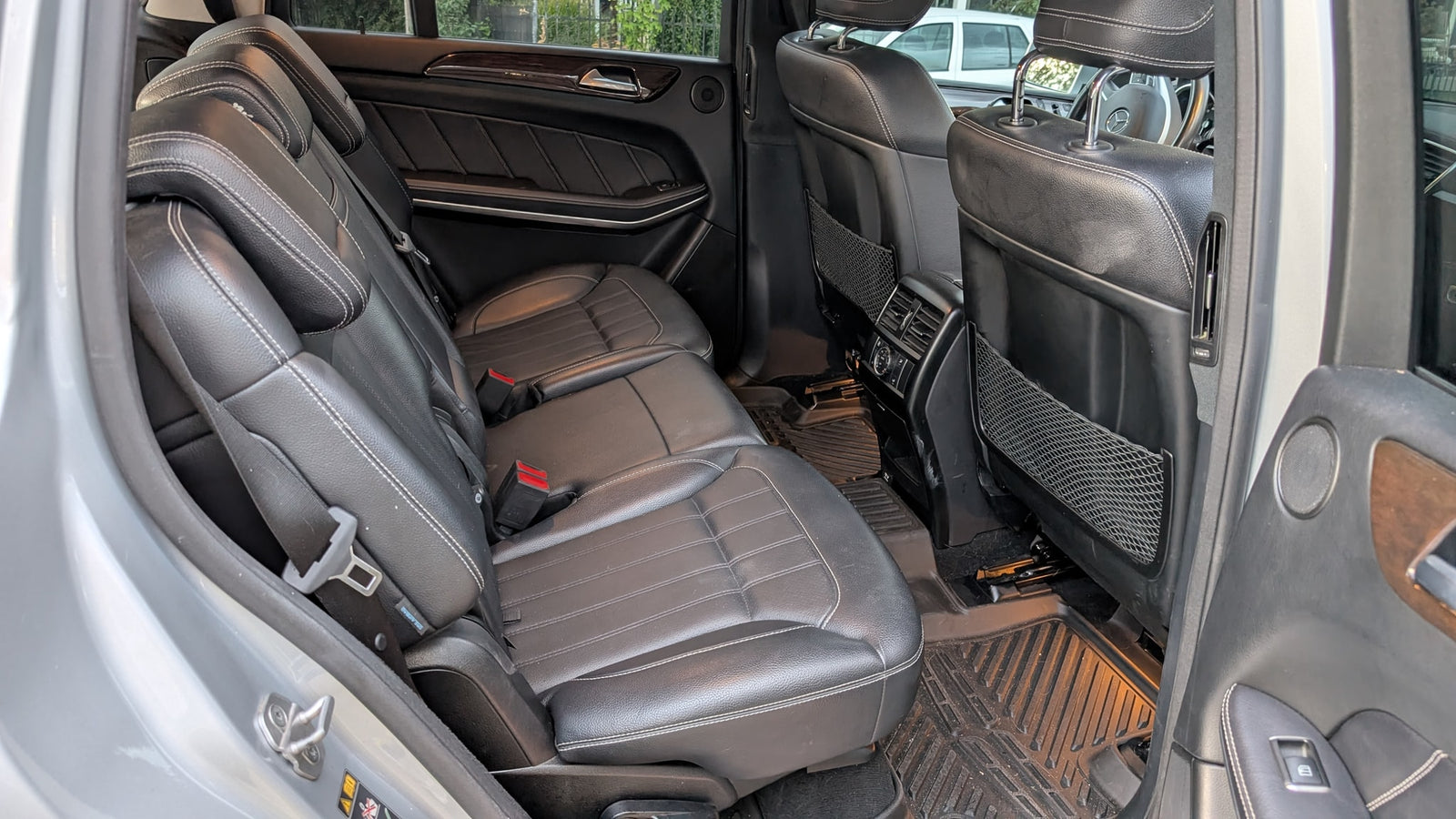 Roomy vehicle interior for your RV rental journey, showing black leather rear seats with white stitching and durable floor mats.