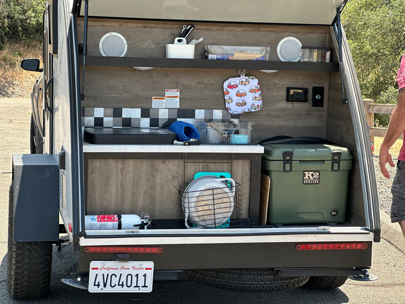 RV rental galley kitchen: fully stocked with a K2 cooler, stove, and essentials, neatly organized for outdoor adventure.