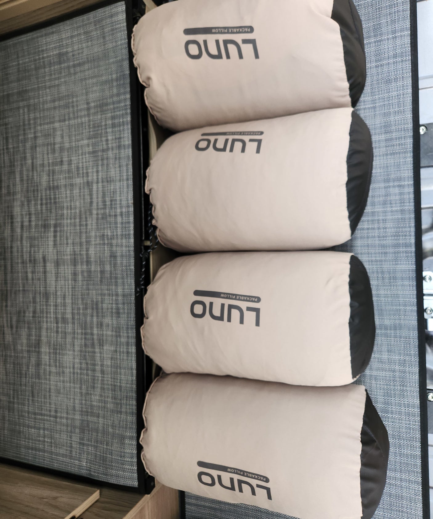 Four Luno Packable Pillows are neatly stacked in an RV rental interior.