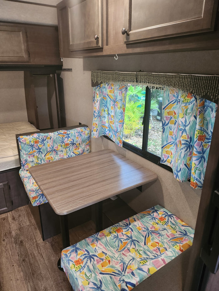 and faux stone backsplash with a window view.|RV rental kitchen: Compact space featuring a modern stove