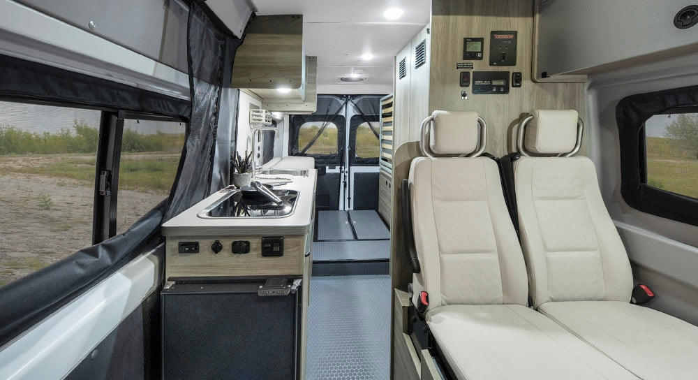surrounded by mountains under a clear sky.|Explore this RV rental's interior with a compact kitchen