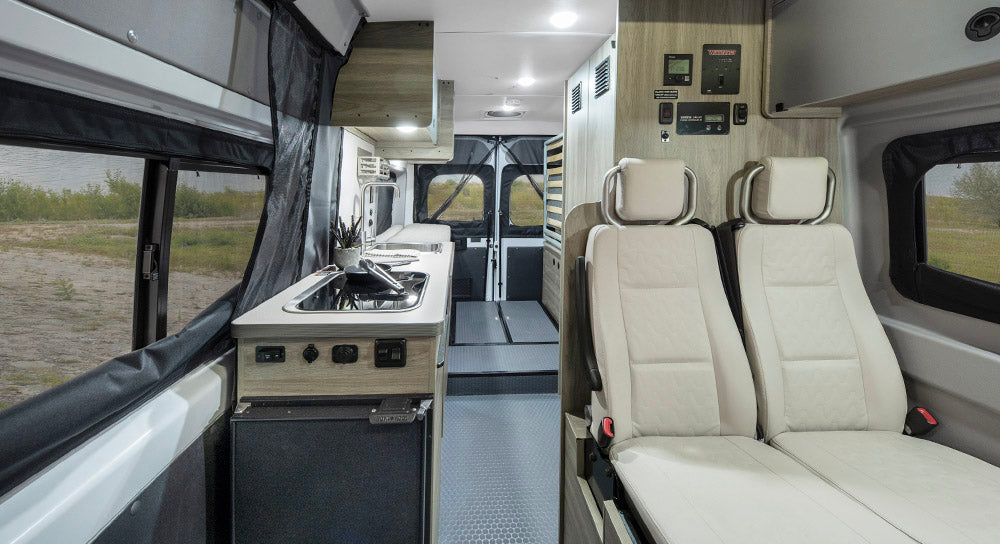 surrounded by mountains under a clear sky.|Explore this RV rental's interior with a compact kitchen