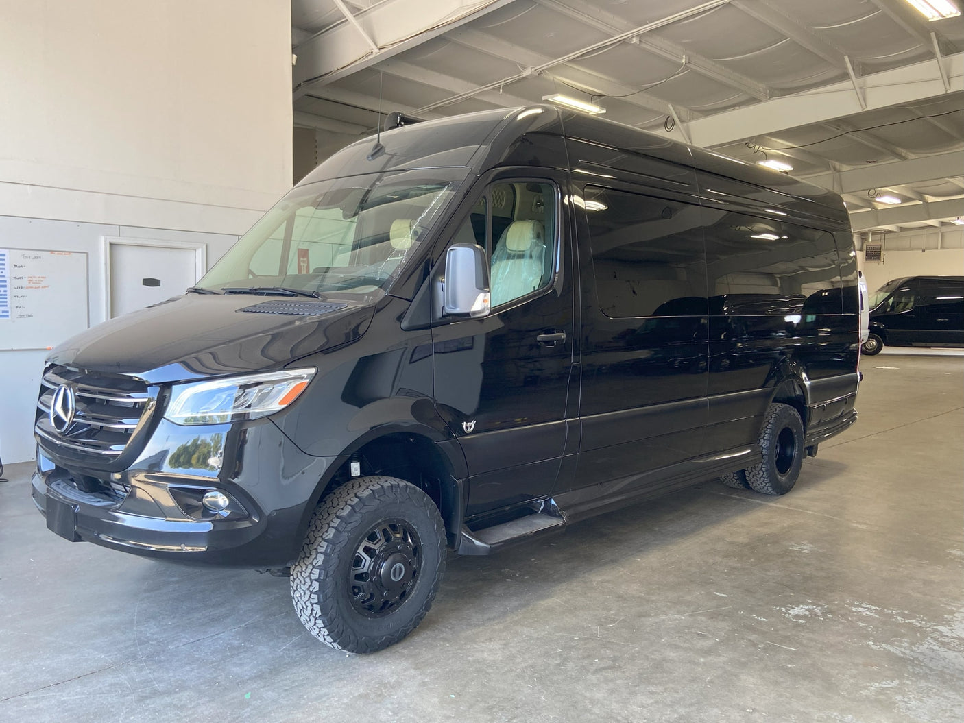 sunny day with people.|Step into luxury! This RV rental boasts a spacious custom interior with plush cream seating