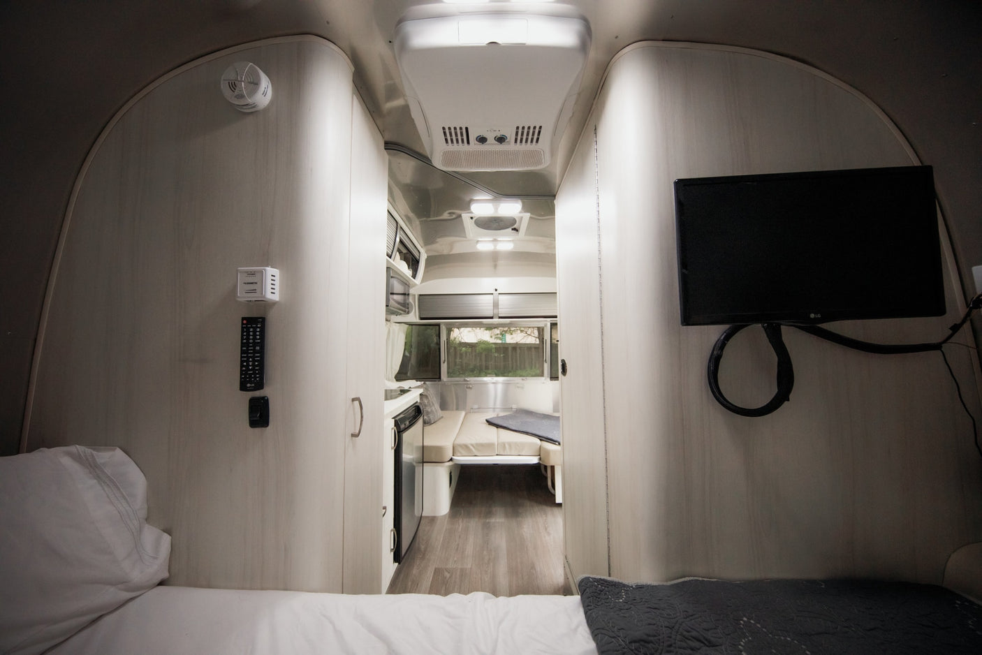 Inside this modern RV rental, find a comfortable bed, compact kitchen, dinette, and TV for your travels.