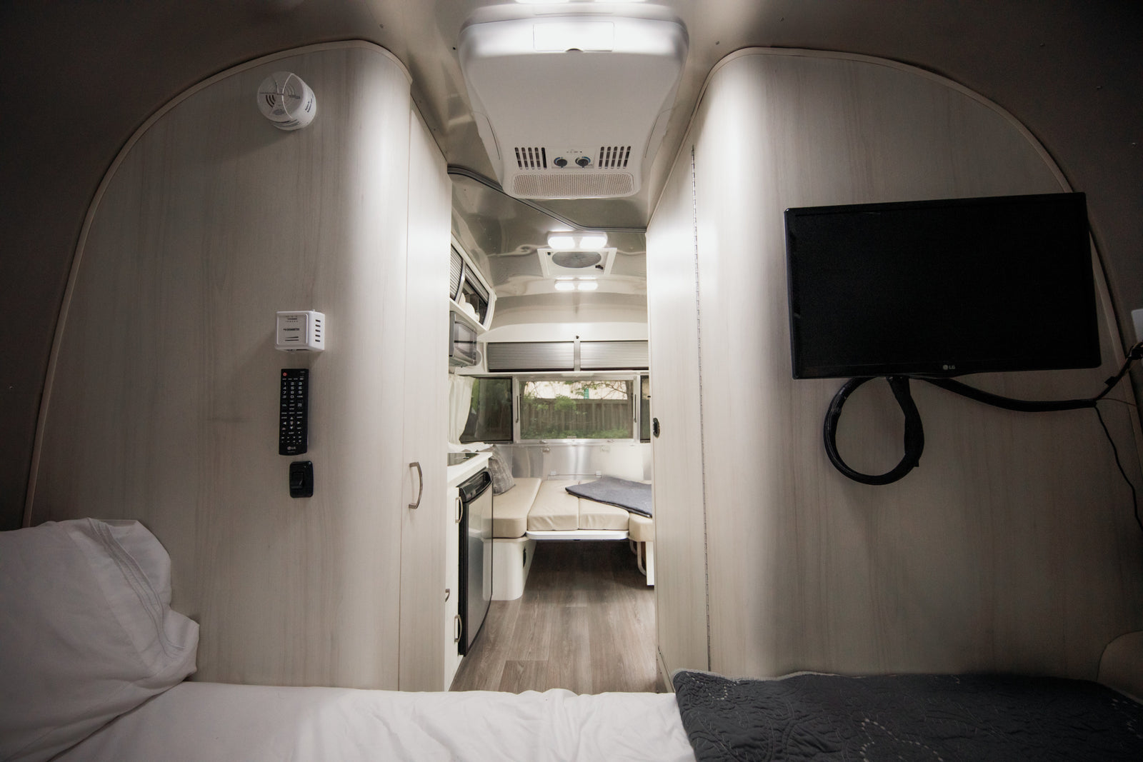 Inside this modern RV rental, find a comfortable bed, compact kitchen, dinette, and TV for your travels.