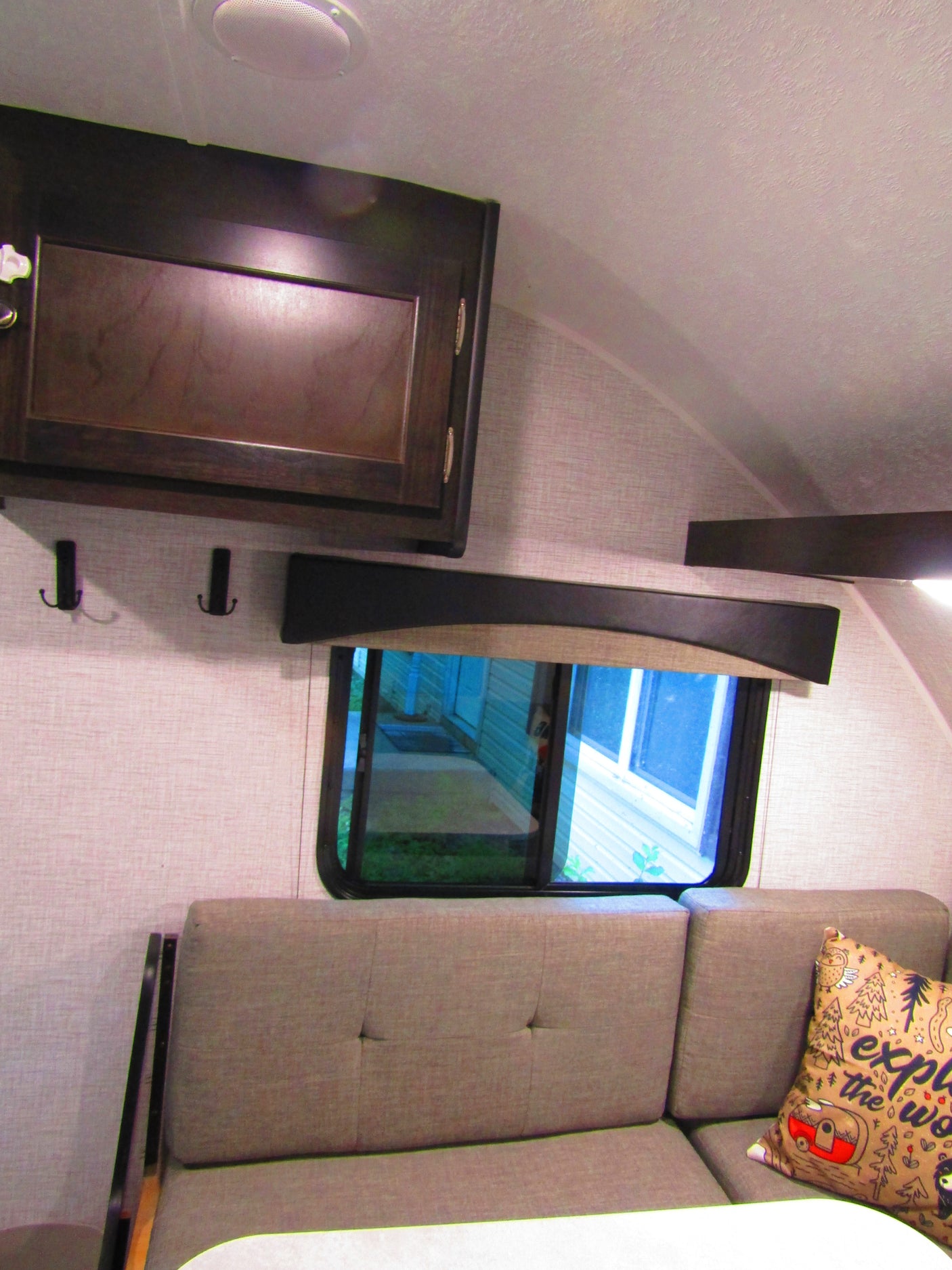 Cozy rv rental interior with overhead storage, comfortable dinette seating, and a window view.