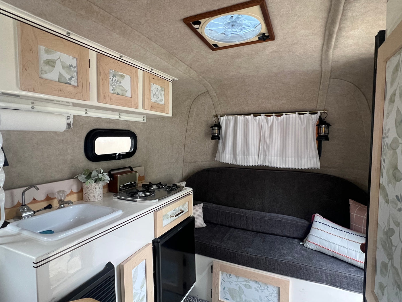 Cozy RV rental interior: kitchenette, fridge, leafy cabinets, and a comfy bench seat. Ideal for travel adventures. — photo 4
