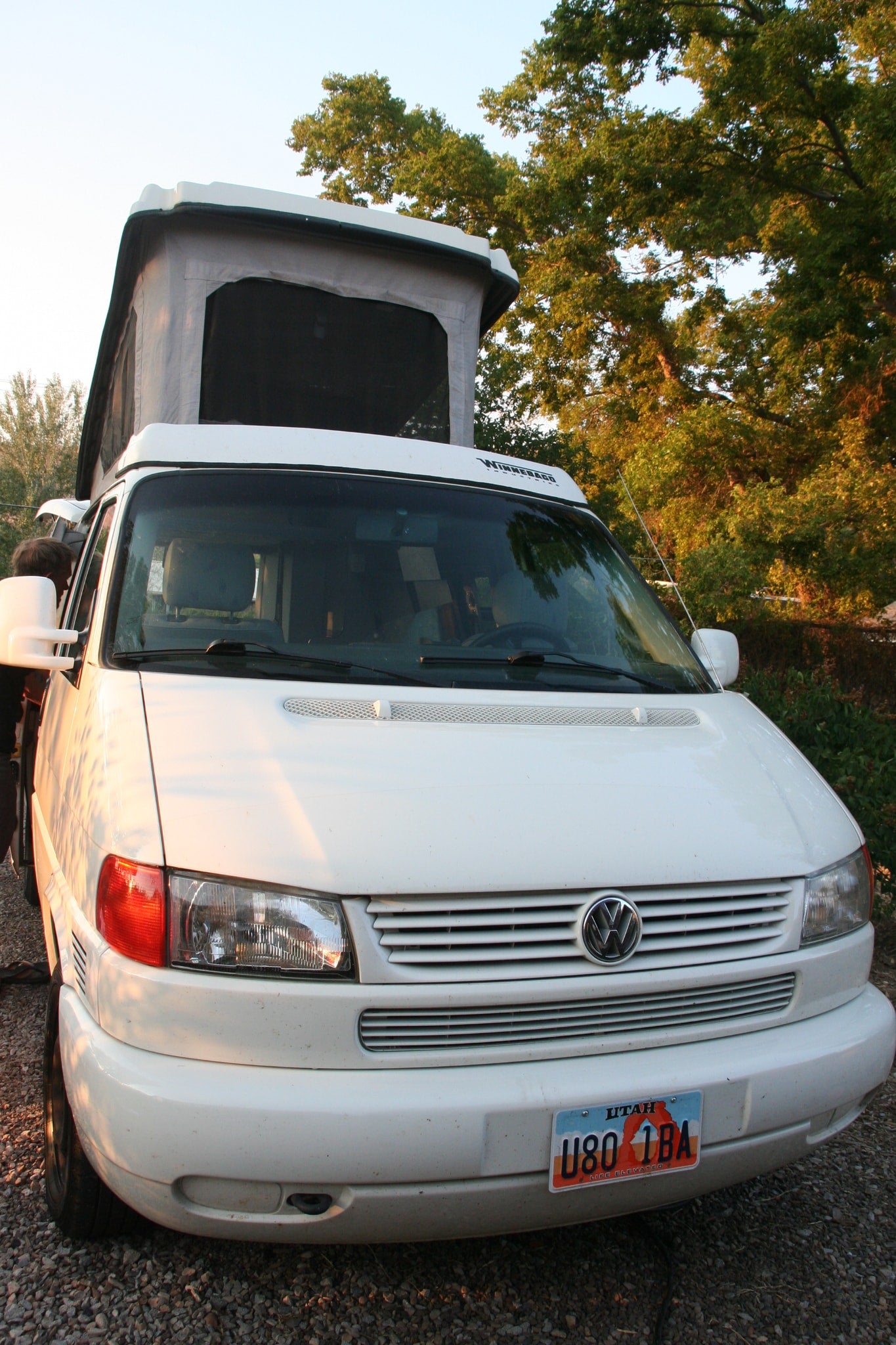 White Volkswagen camper van with pop-top roof open, ready for adventure. Ideal for an RV rental road trip. Utah plate U80 1BA.