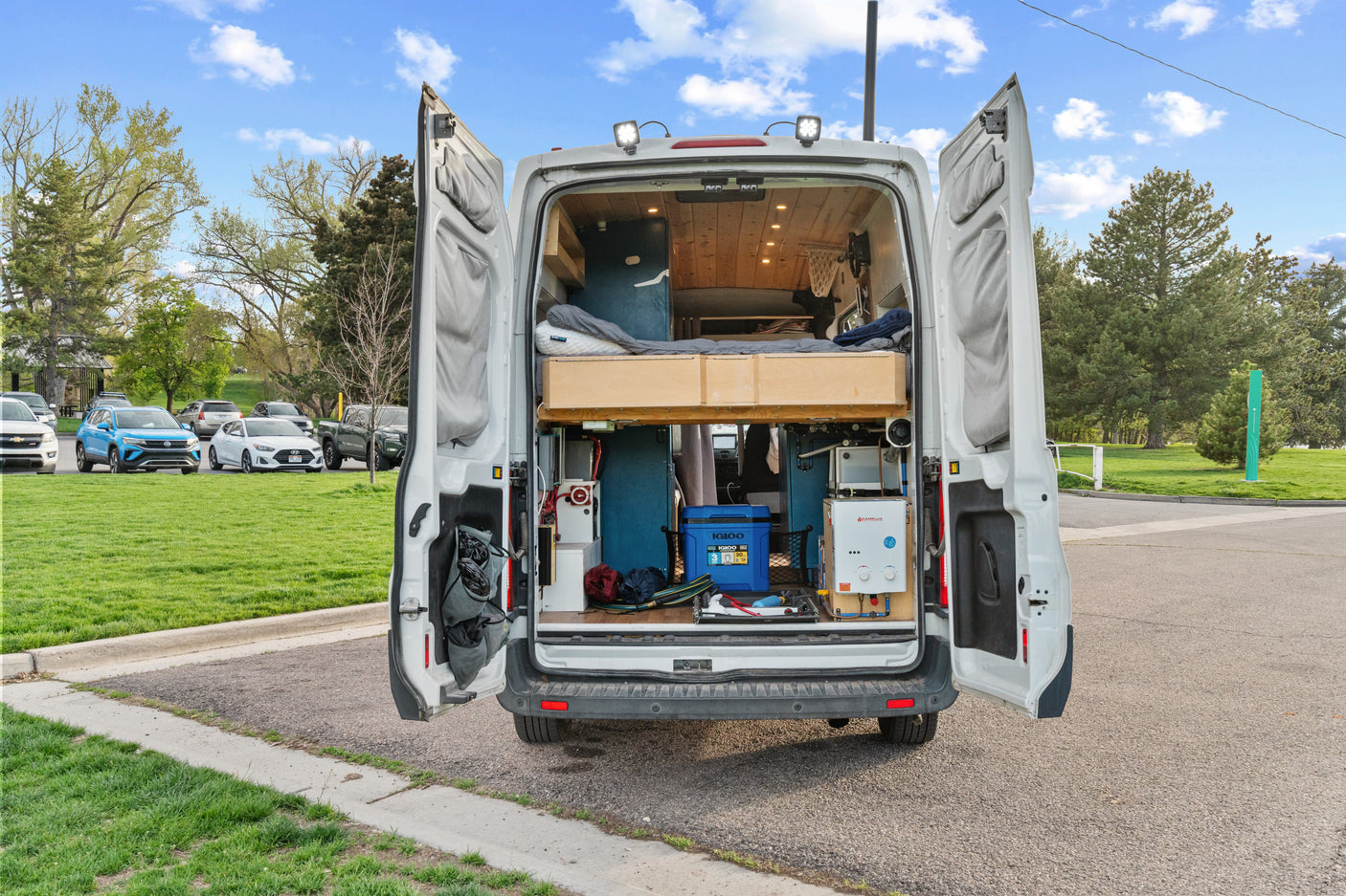 RV rental camper van interior revealed: custom bed, storage, and water heater for off-grid adventures.