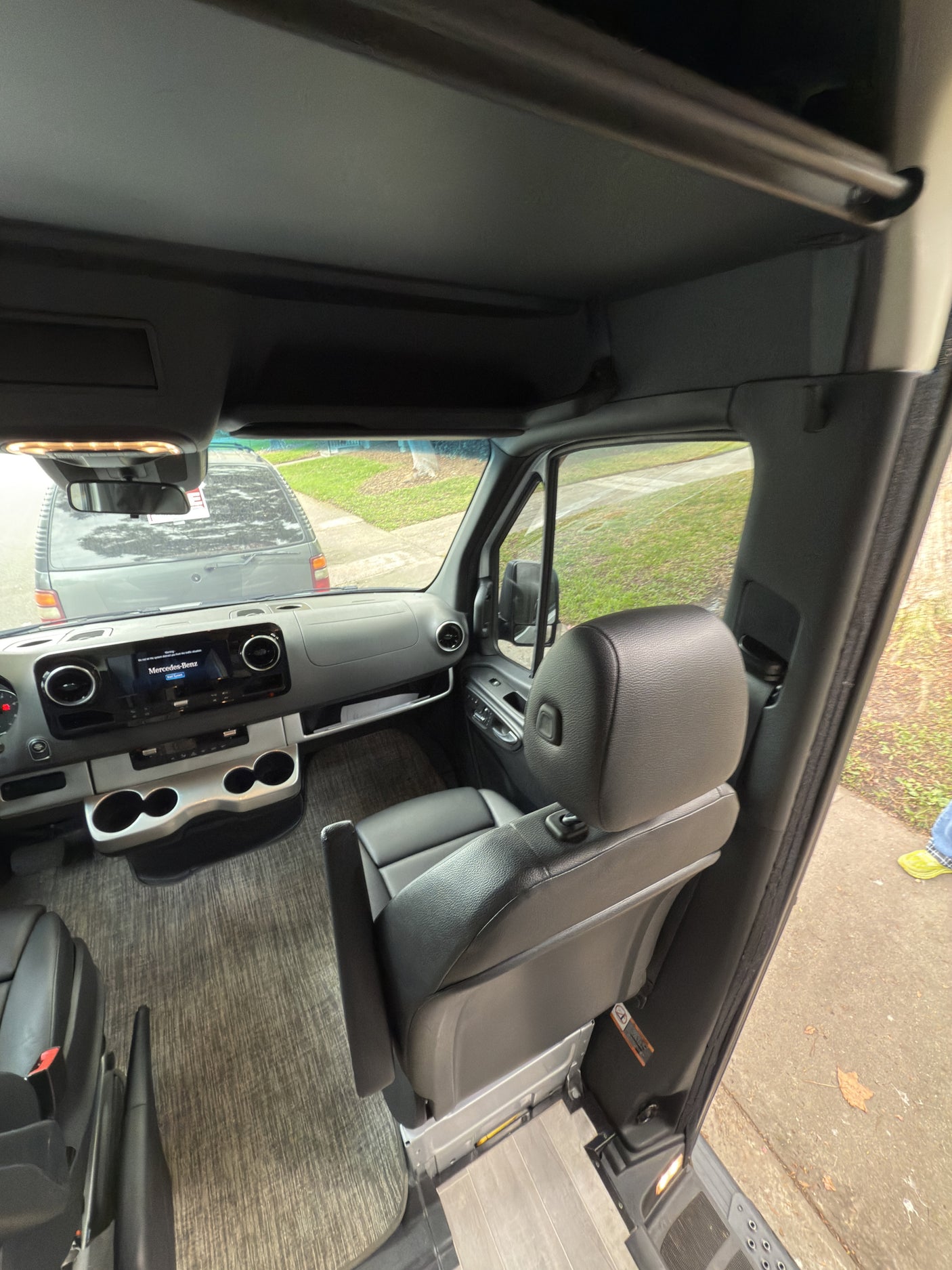 Spacious Mercedes-Benz RV rental cabin. See the modern dashboard, comfortable seats, and front view of the road.