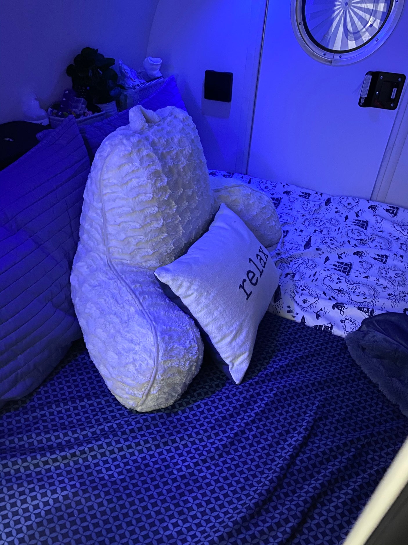 Cozy blue-lit bed setup in an RV rental, perfect for relaxing after travel. Features plush pillows and themed bedding.