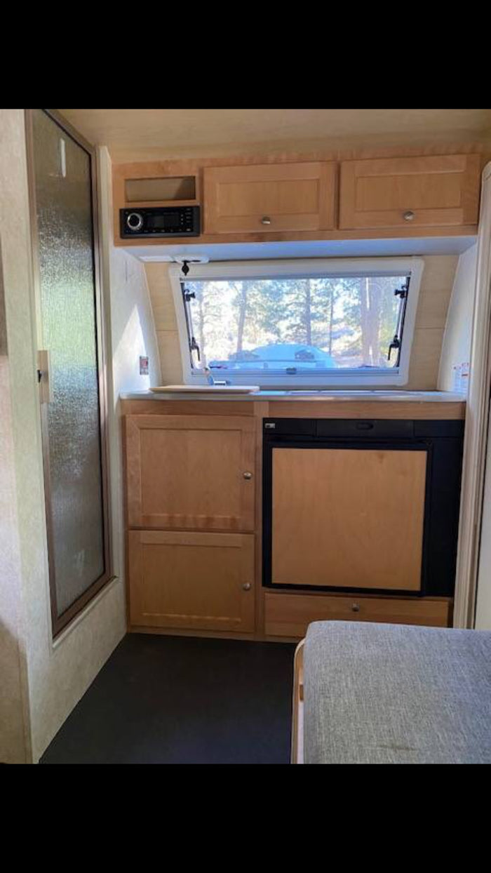 showing a cozy interior and exterior setup.|This RV rental Boondock Edition camper enjoys a beautiful sunset campsite. Perfect for off-grid adventure camping.|Explore an rv rental's compact interior: shower stall