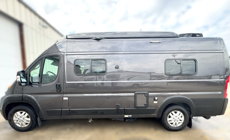 Side view of a sleek gray camper van, ideal for RV rental. Features include a raised roof, side windows, and a rooftop AC unit.