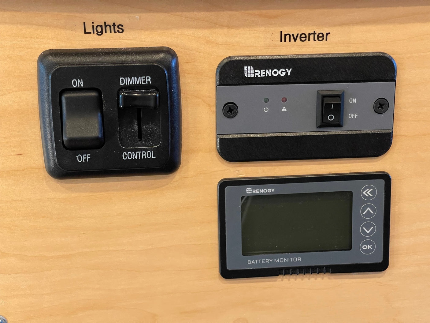 RV rental control panel: lights (on/off, dimmer), Renogy inverter (on/off, status lights), and battery monitor with display.