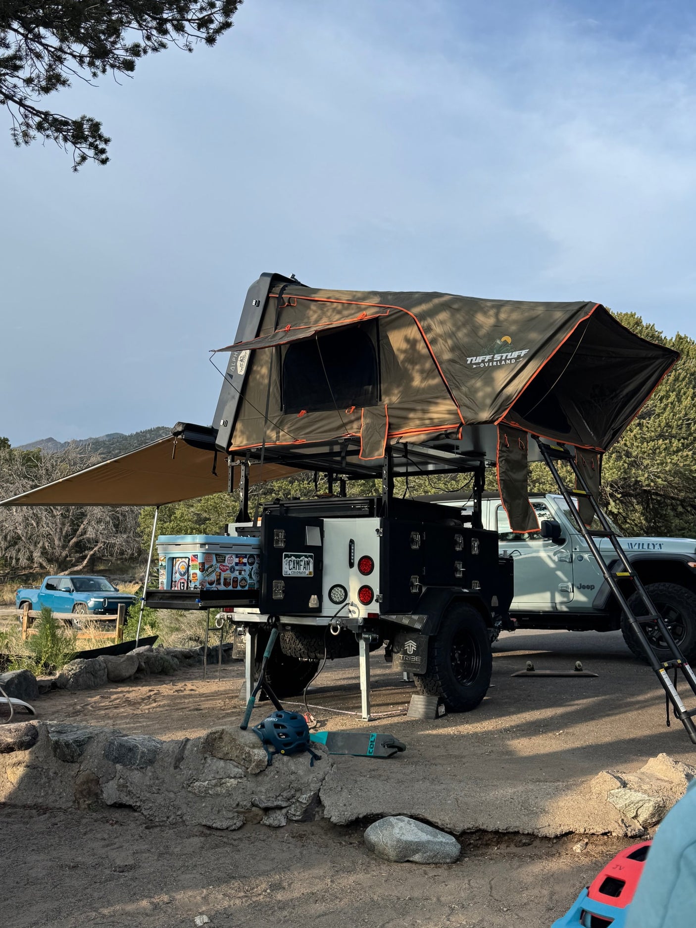 Overlanding trailer with Tuff Stuff rooftop tent set up for rugged camping. Perfect for your next rv rental adventure with a Jeep nearby.