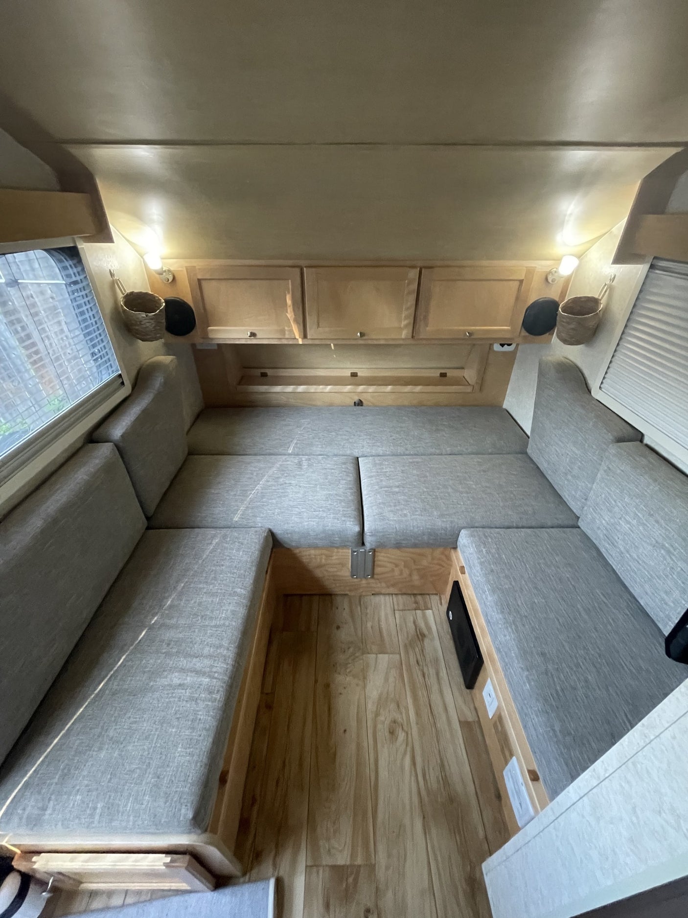 and light wood cabinets.|RV rental interior showcasing a spacious gray bed
