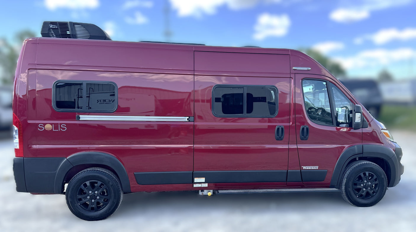 A sleek red Winnebago Solis camper van, perfect for an RV rental adventure, parked outdoors on a sunny day.