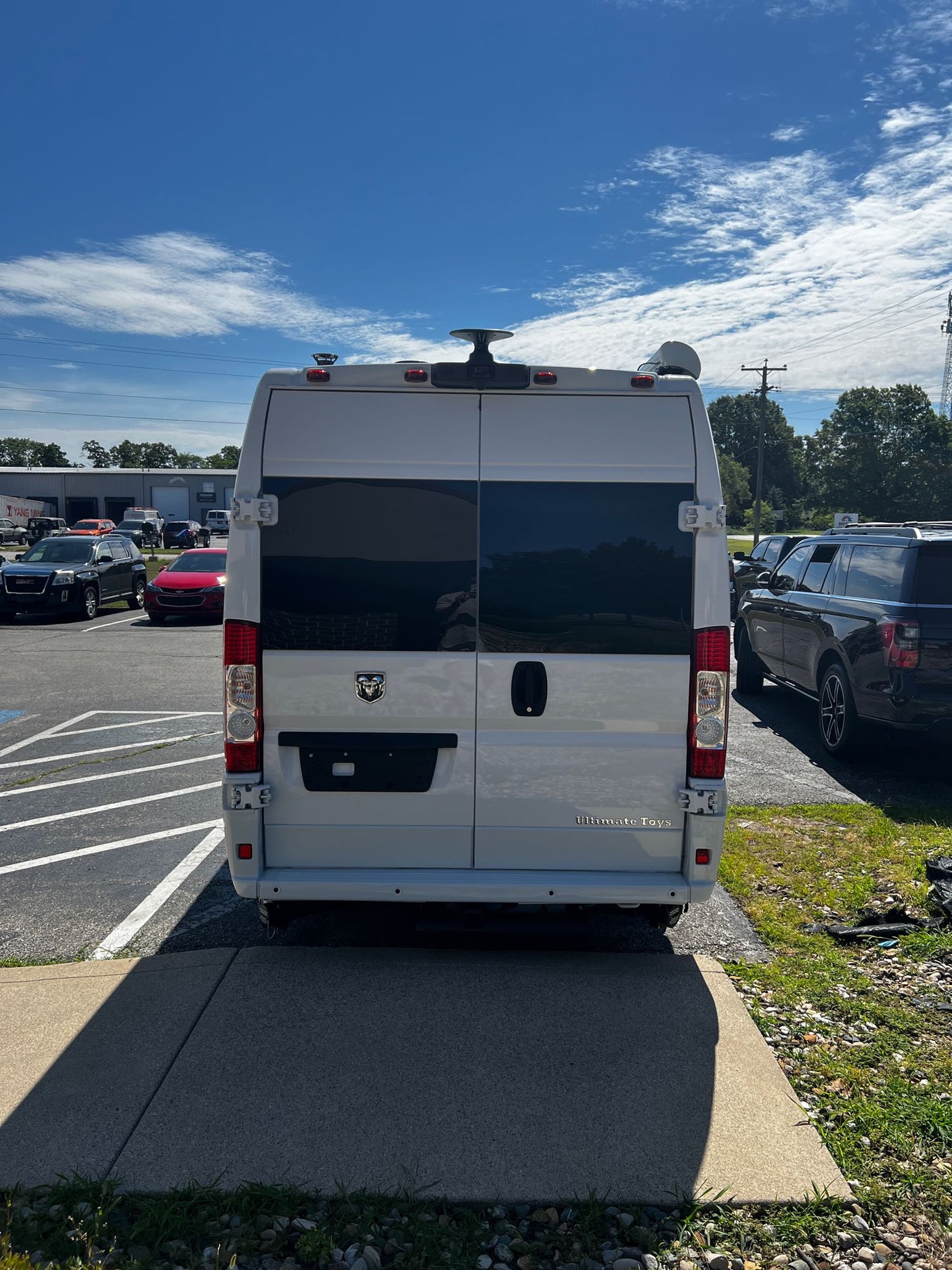 and rear bathroom.|Frontal view of a white Ram ProMaster camper van