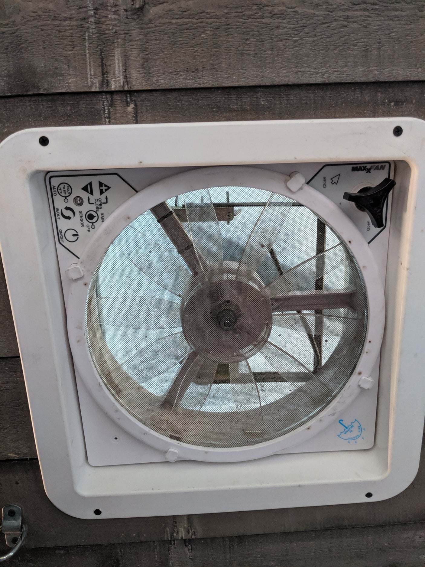 A MaxxAir RV vent fan, common in an rv rental, shows its controls and dirty screen for air circulation.