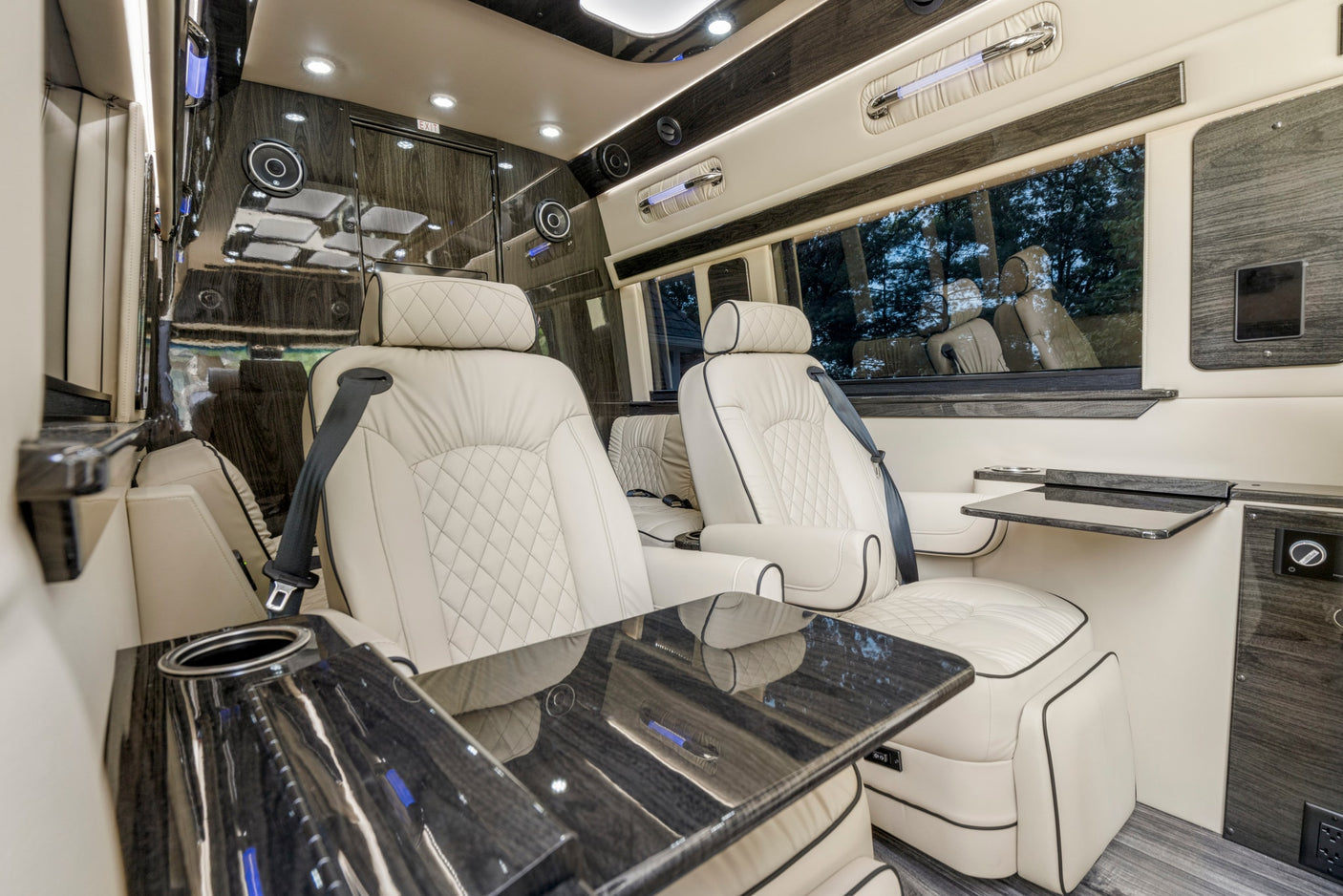Luxurious RV rental interior features cream leather seats, glossy wood accents, and soft ambient lighting for ultimate comfort.