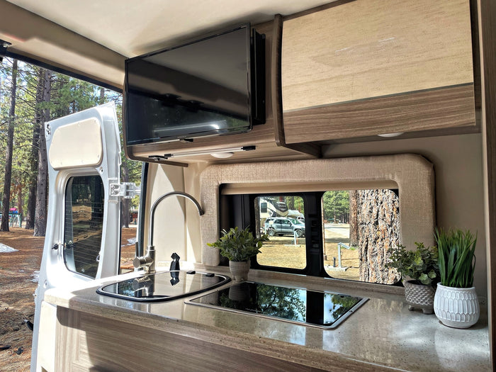 colorful rock cliffs in a scenic national park.|Back doors open on a cozy RV rental. Modern camper van interior features a kitchen