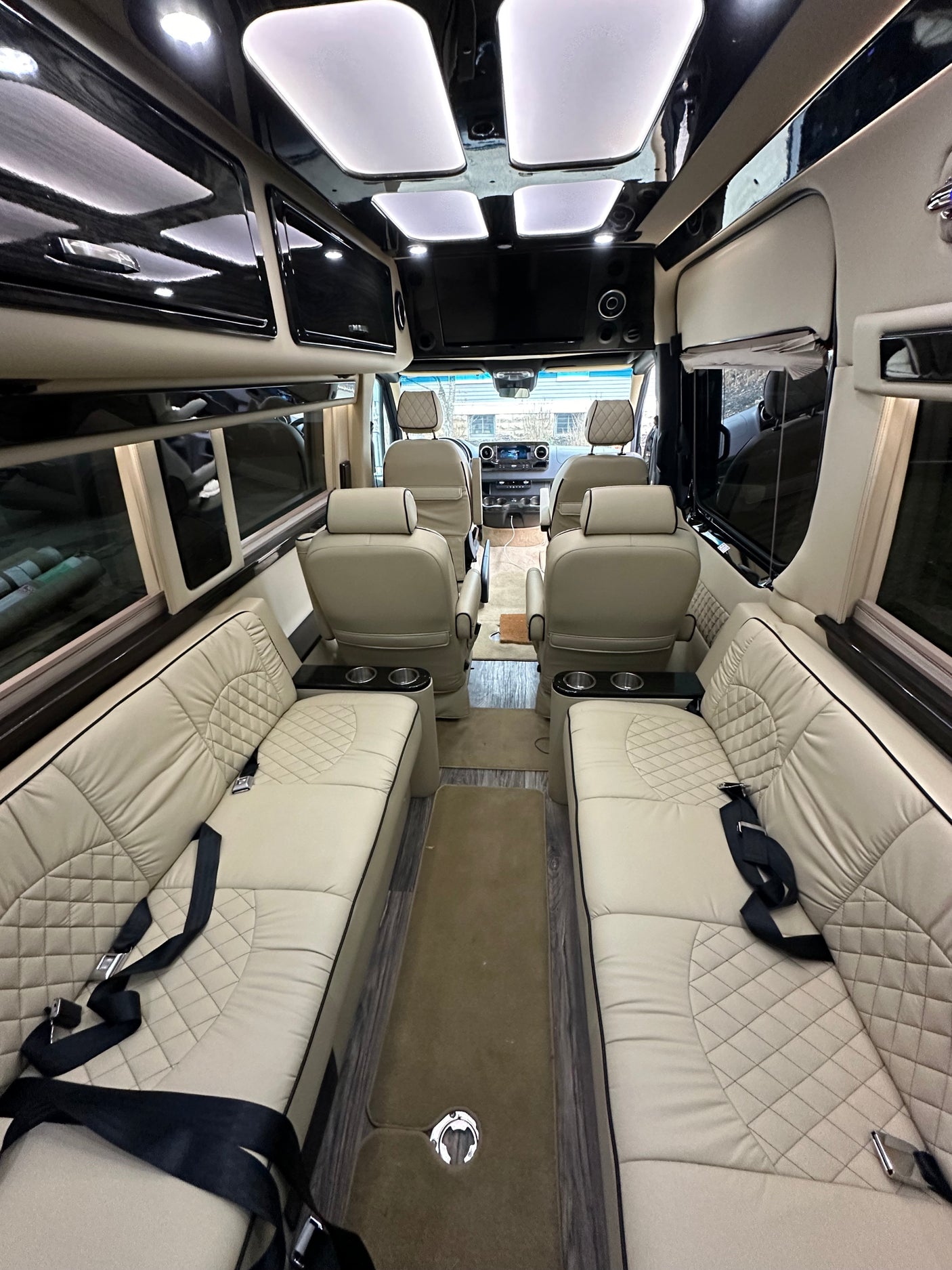 Explore this opulent rv rental interior: cream quilted leather seating, sleek black trim, ambient lighting, and spacious comfort.