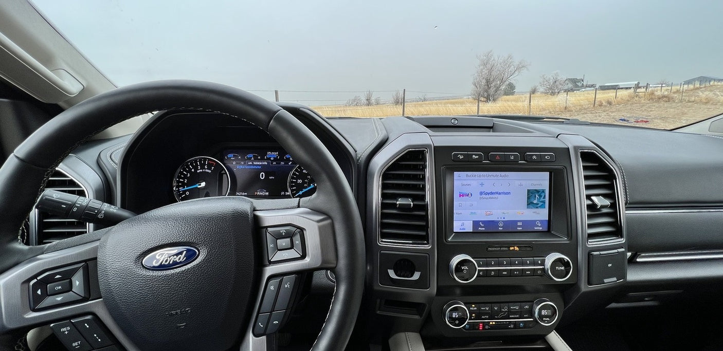 Ford vehicle interior, dashboard, and rural landscape view. Ready for an RV rental road trip!