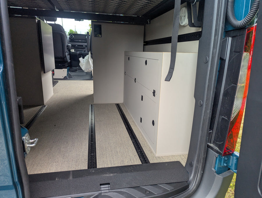 RV rental: Spacious camper van interior with modular cabinets, comfy carpet, and track flooring system.