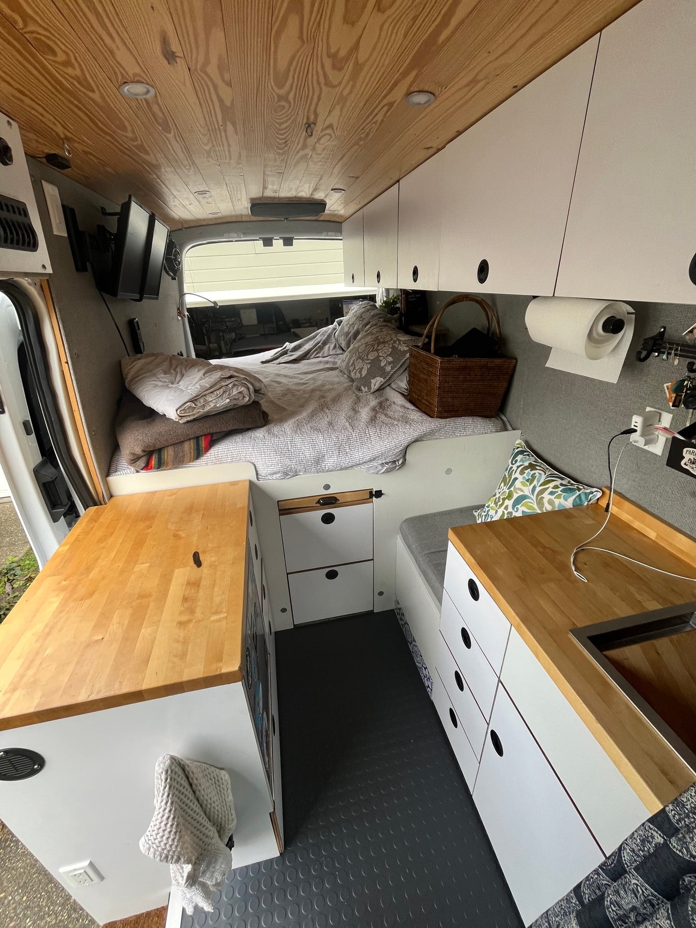 Spacious camper van interior, ideal for your next rv rental. Features comfy bed, kitchen, storage, and wooden ceiling. — photo 10