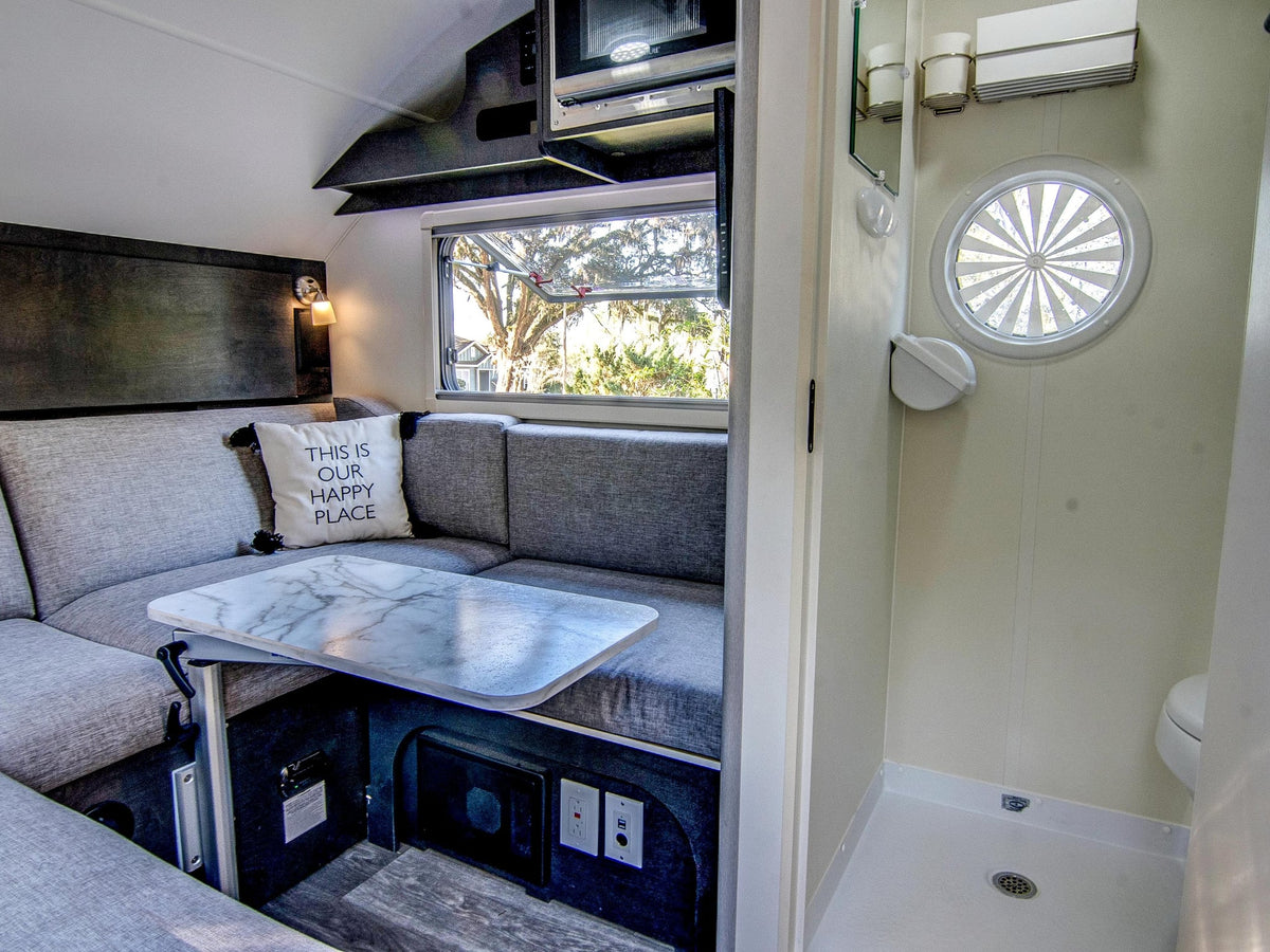and scenic views from the windows of this T@D camper.|Step into comfort! This cozy rv rental features a bright interior with a U-shaped dinette — photo 15