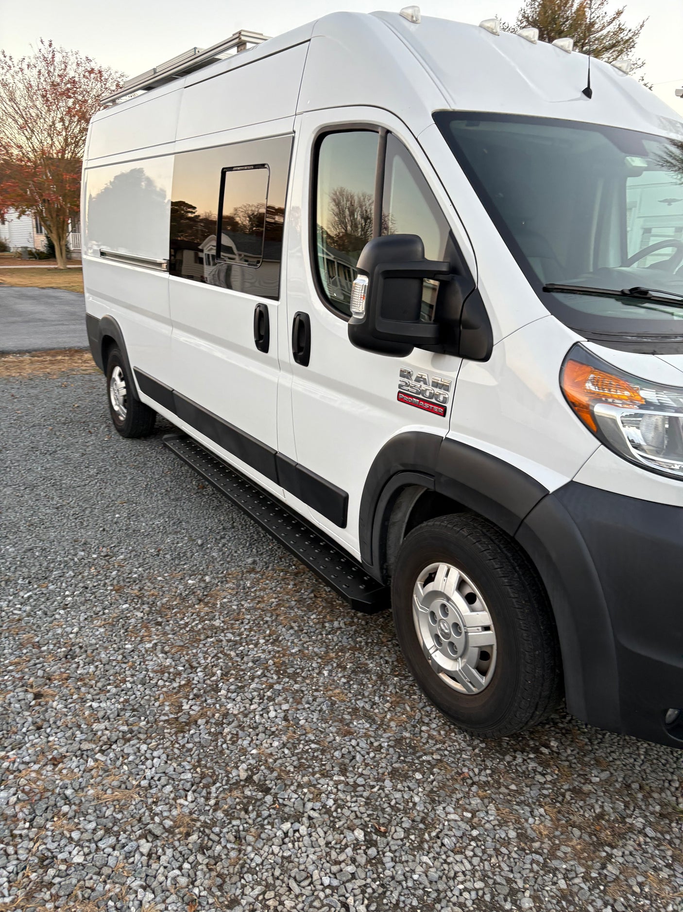 White Ram ProMaster camper van for RV rental, showcasing its side profile, windows, and practical step.
