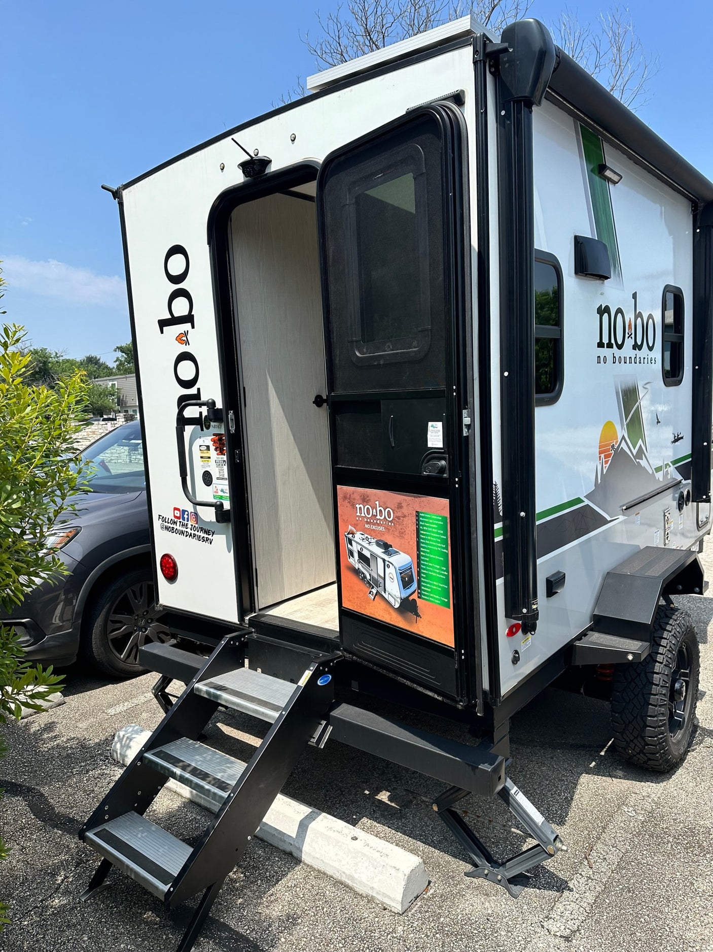 Rugged NoBo travel trailer with open door & extended steps, perfect for your next RV rental adventure.