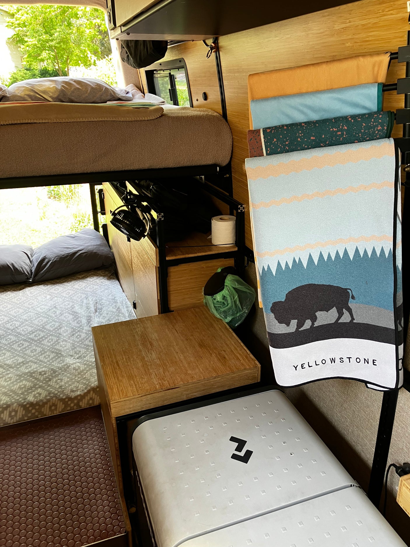 This RV rental features bunk beds, compact storage, a fan, fridge, and Yellowstone-themed decor for adventure.