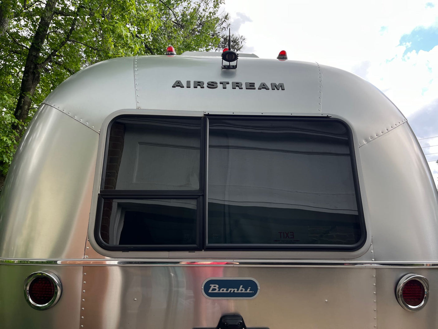 hooked up for a cozy stay.|Perfect for an RV rental getaway: A white SUV hitches to a shiny Airstream Bambi travel trailer