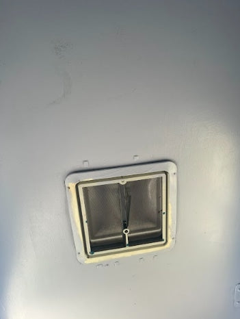 RV rental interior ceiling, featuring a grey screened vent. Common RV ceiling fan/vent for ventilation.