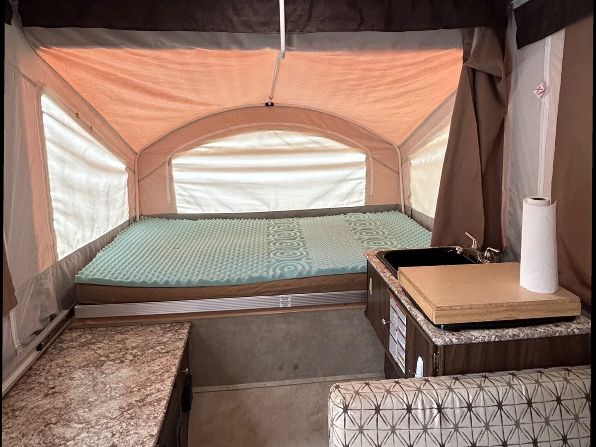 and microwave. Pop-up camper interior.|RV rental interior showing a ceiling-mounted Coleman Mach AC — photo 7