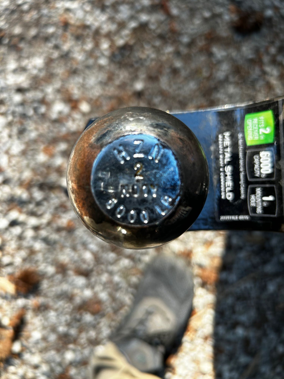 A close-up of a well-used metallic trailer hitch ball (5000lb) and receiver (6000lb) for RV rental towing. — photo 12