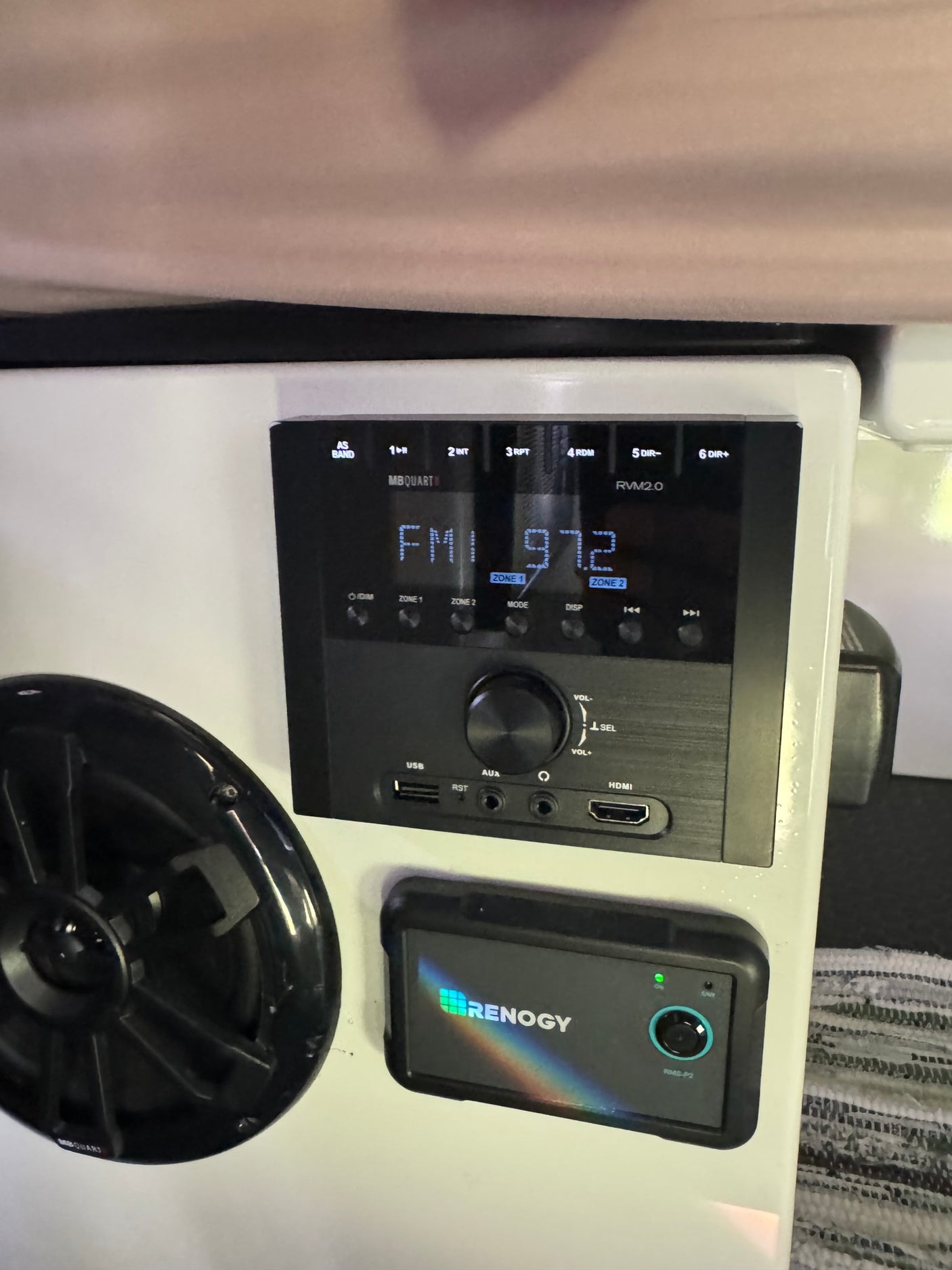 RV rental interior featuring an MB Quart stereo (FM 97.2), a speaker, and a Renogy battery monitor control panel.
