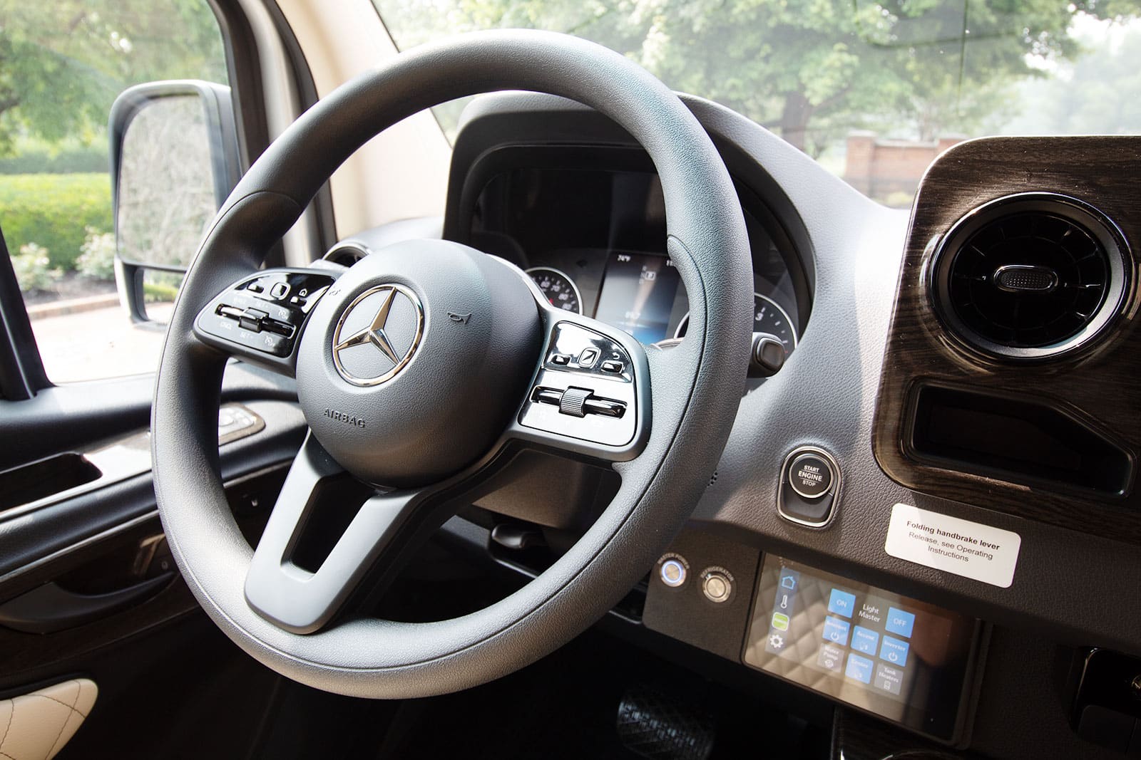 Luxury Mercedes-Benz RV rental interior, showing the steering wheel, dashboard, and advanced control panel.