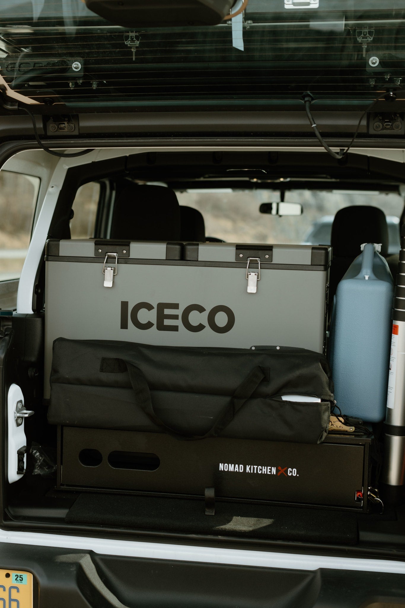 Back of vehicle showing ICECO fridge, Nomad Kitchen, and camping gear. Ideal for an RV rental or overland trip.