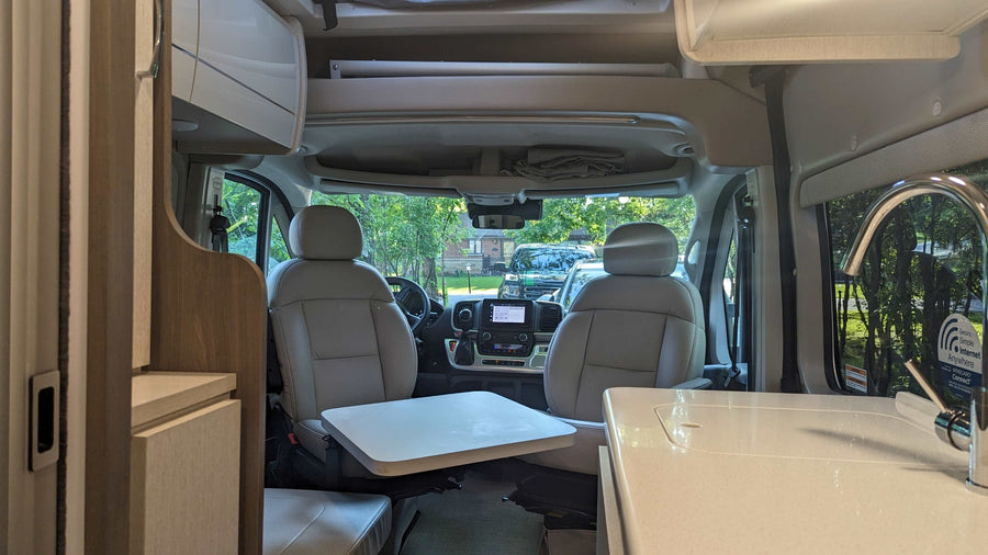 perfect for outdoor adventures.|Discover adventure with this pop-top RV rental: a silver camper van with an extended awning at a wooded campsite.|Work on the go! Inside a spacious rv rental