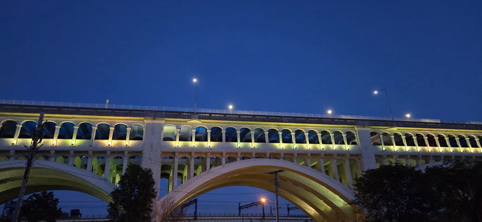 Illuminated multi-arched bridge at night under a deep blue sky, a scenic stop on your RV rental route.