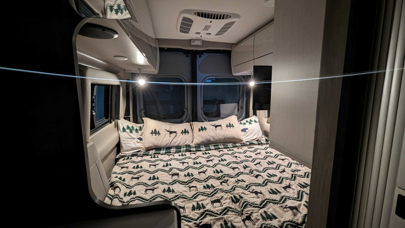 and a compact kitchen counter with a sink.|Experience the cozy interior of this modern RV rental