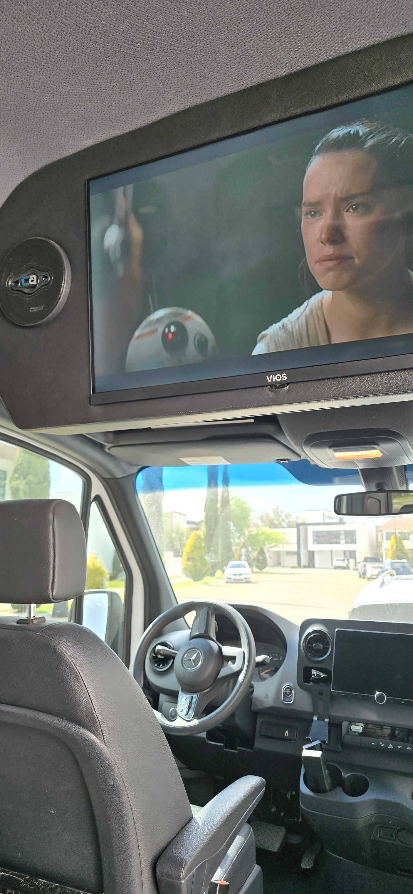 Spacious RV rental interior with overhead entertainment. Rey & BB-8 on screen in a Mercedes Sprinter van.