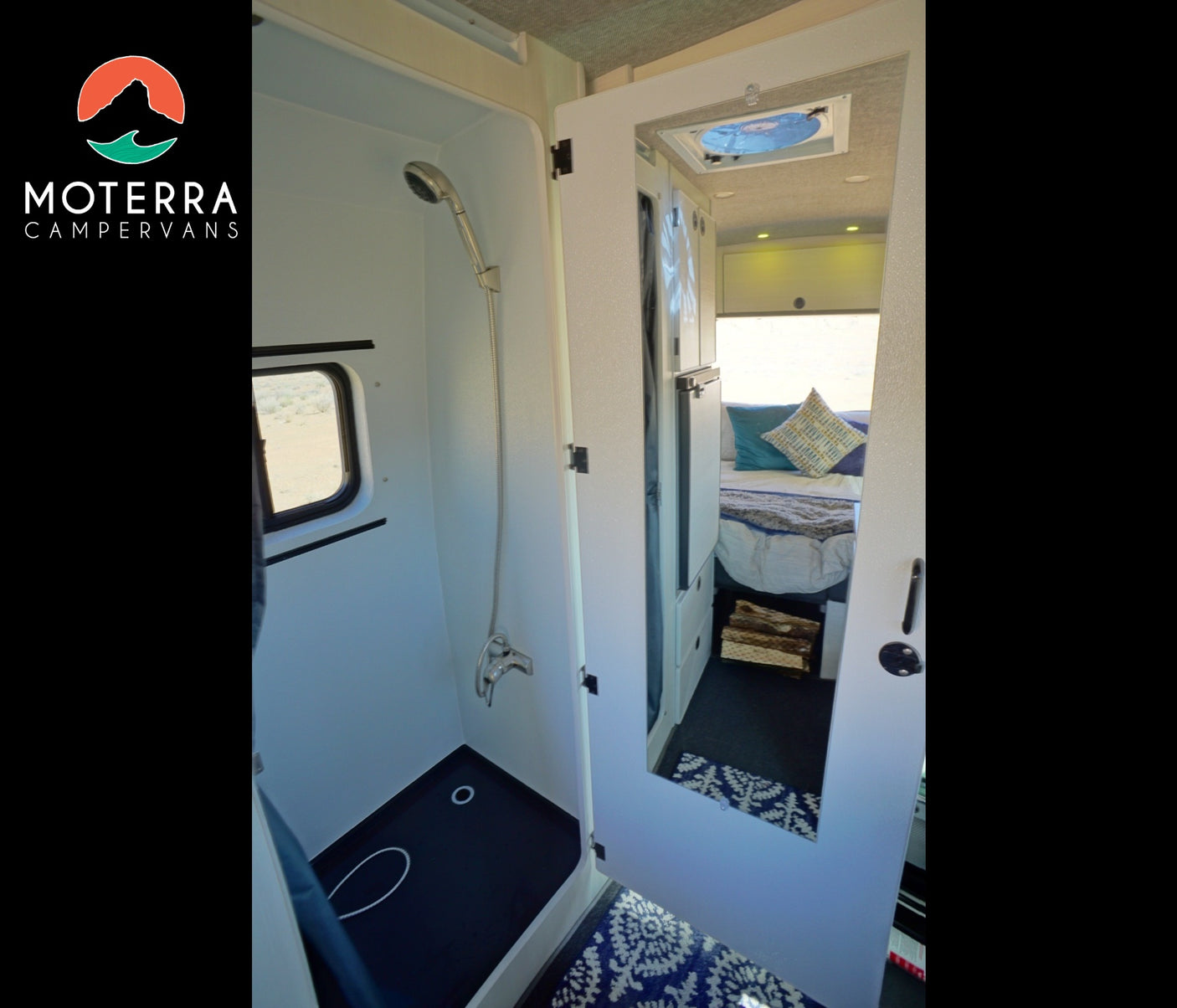 Modern RV rental interior: walk-in shower on left, mirrored cabinet reflecting bed & storage on right.