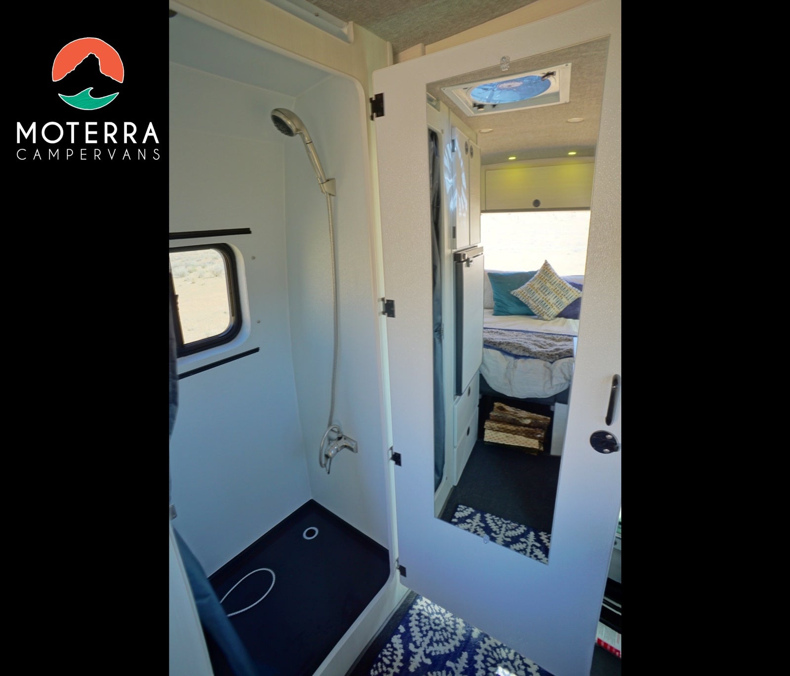 Modern RV rental interior: walk-in shower on left, mirrored cabinet reflecting bed & storage on right.